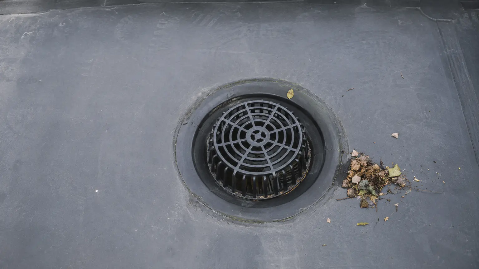 Flat roof outlet surrounded by clean EPDM membrane
