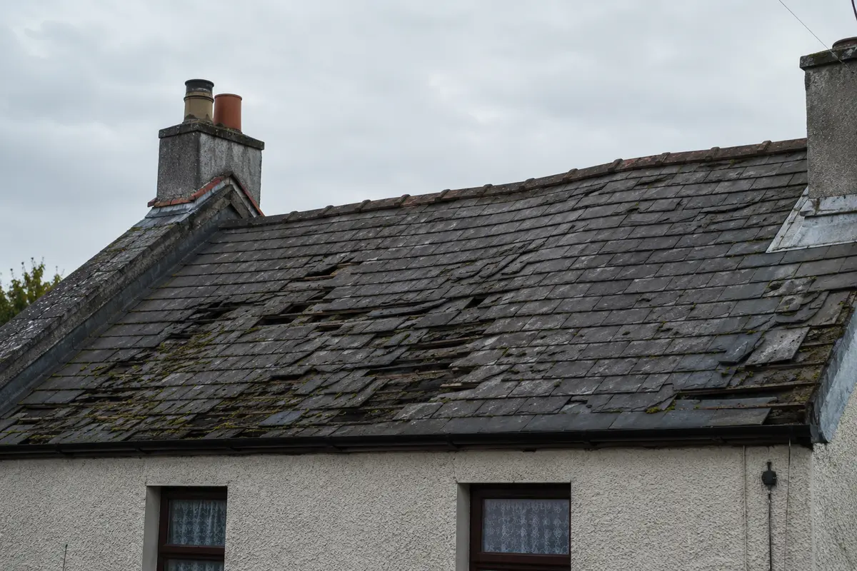 Aged slate roof with slipped and missing slates showing signs it needs replacing
